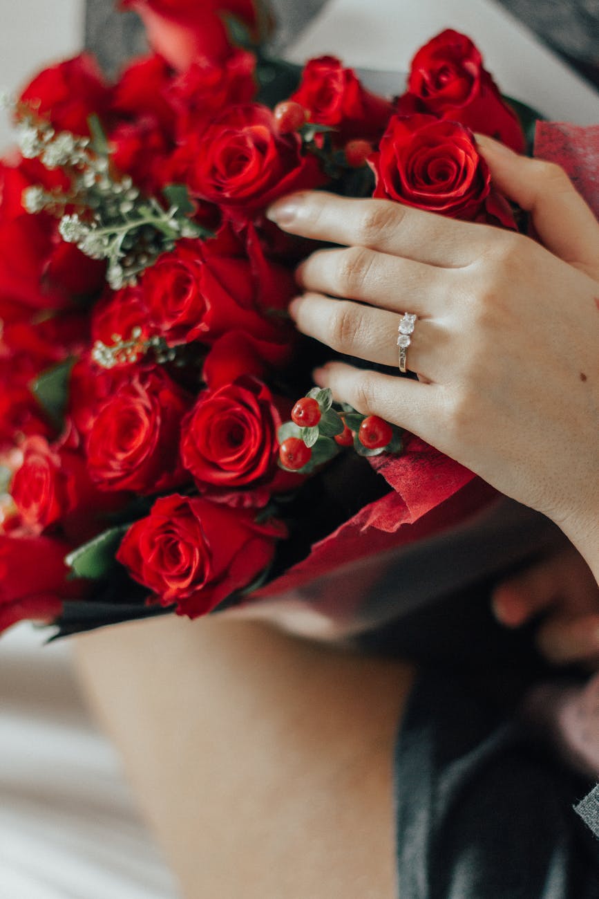person holding bouquet of red roses